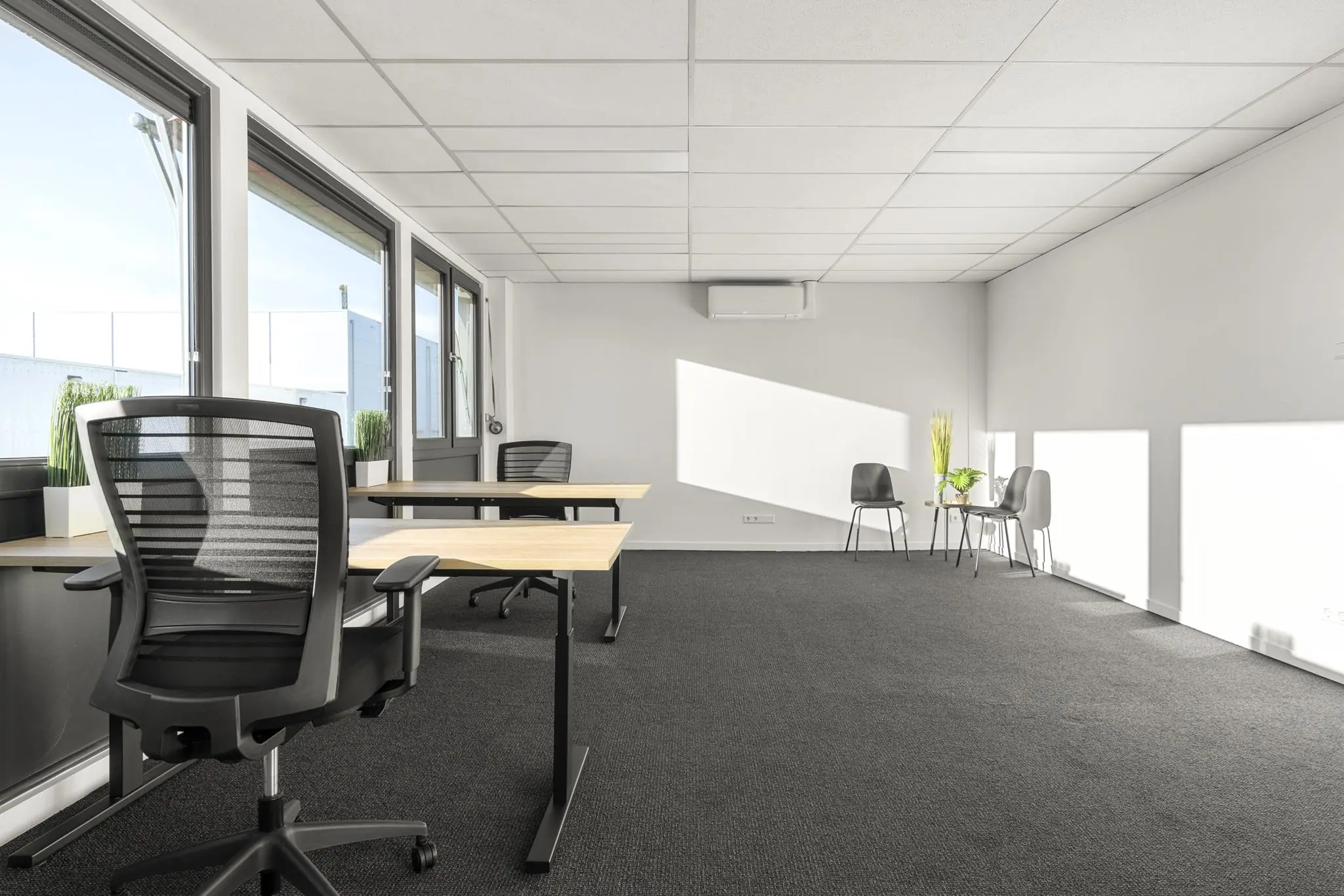 Moderne, lichte kantoorruimte aan de Nijverheidsweg met bureaus, stoelen en een zithoek bij het raam.