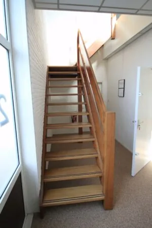 Houten trap met open treden in een helder verlichte hal aan de Nevadadreef.