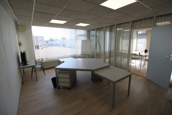 Kantoorruimte aan de Nevadadreef met modern bureau, groot raam en een whiteboard.