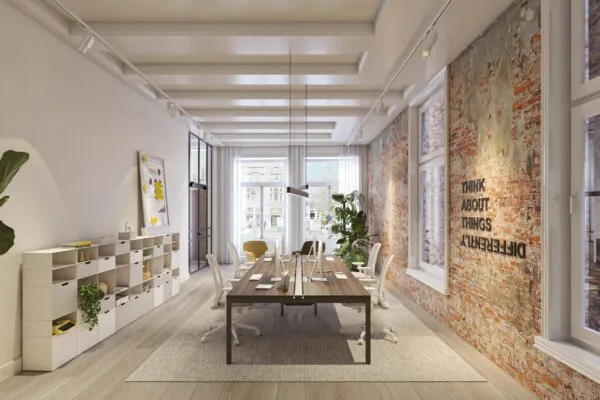 Modern kantoorinterieur aan het Rokin met een lange werktafel, bakstenen muur en de tekst "Think about things differently".