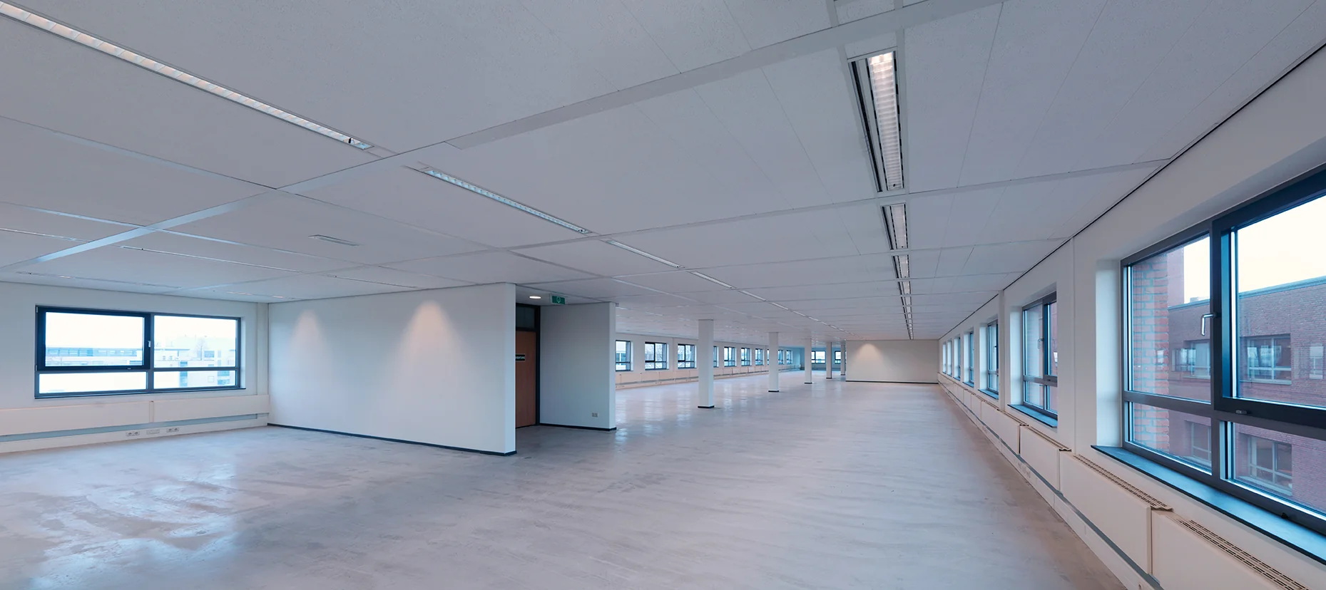 Lichte, ruime en lege kantoorruimte aan de Pompmolenlaan met grote ramen en systeemplafond.