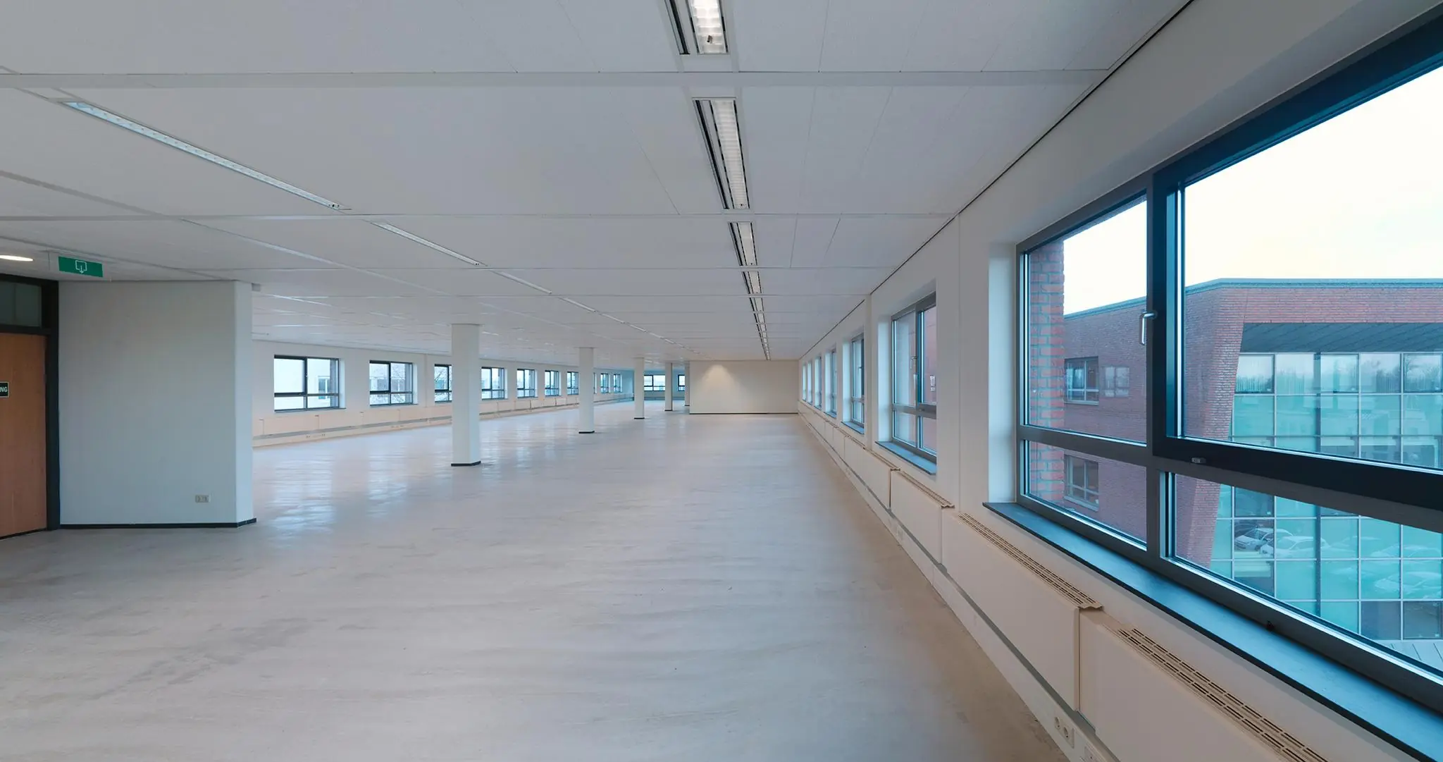 Lichte, ruime en leegstaande kantoorruimte aan de Pompmolenlaan met grote ramen en systeemplafond.