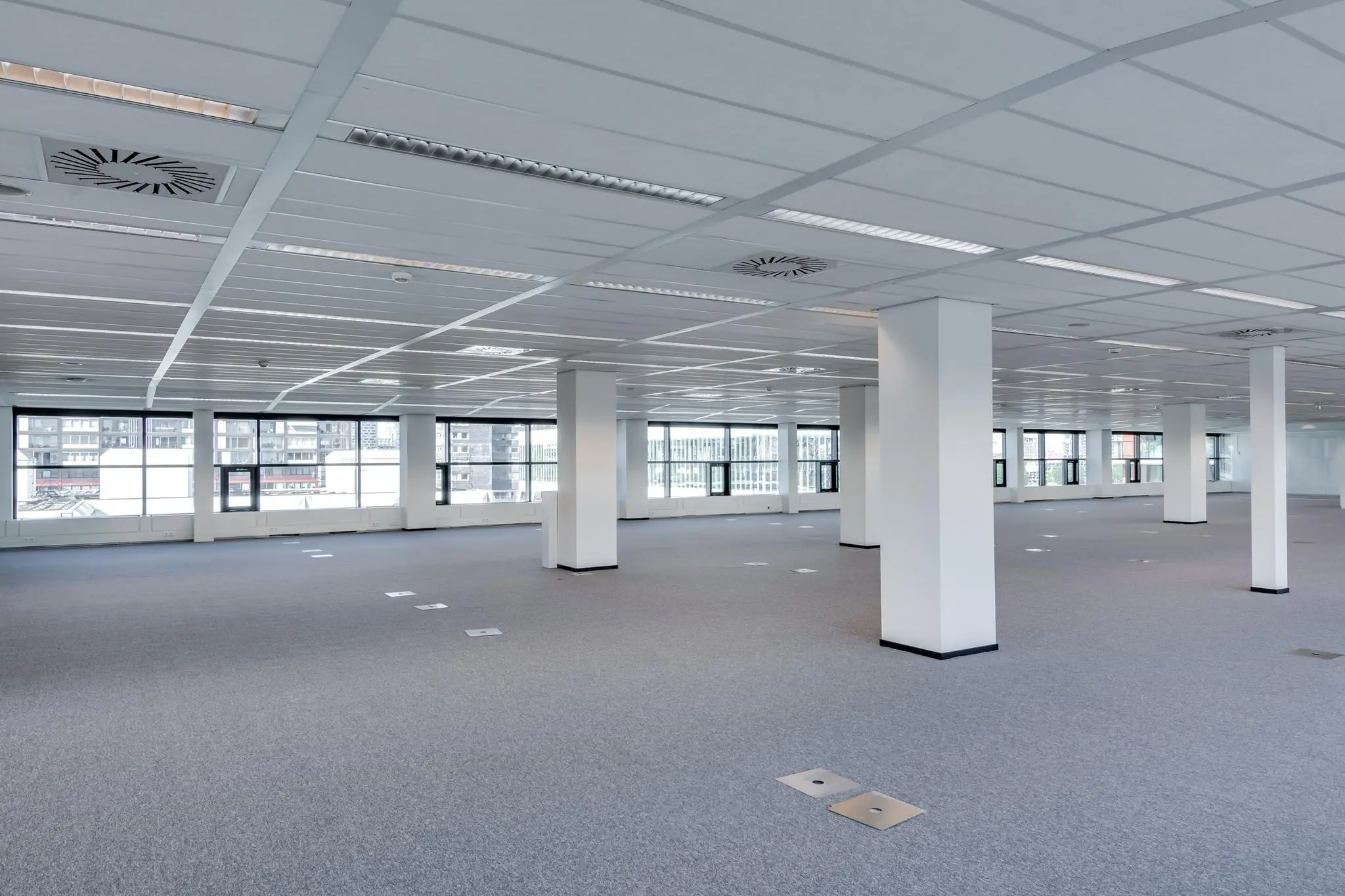 Leeg en modern kantoorpand aan de Westerstraat met grote ramen en systeemplafond.