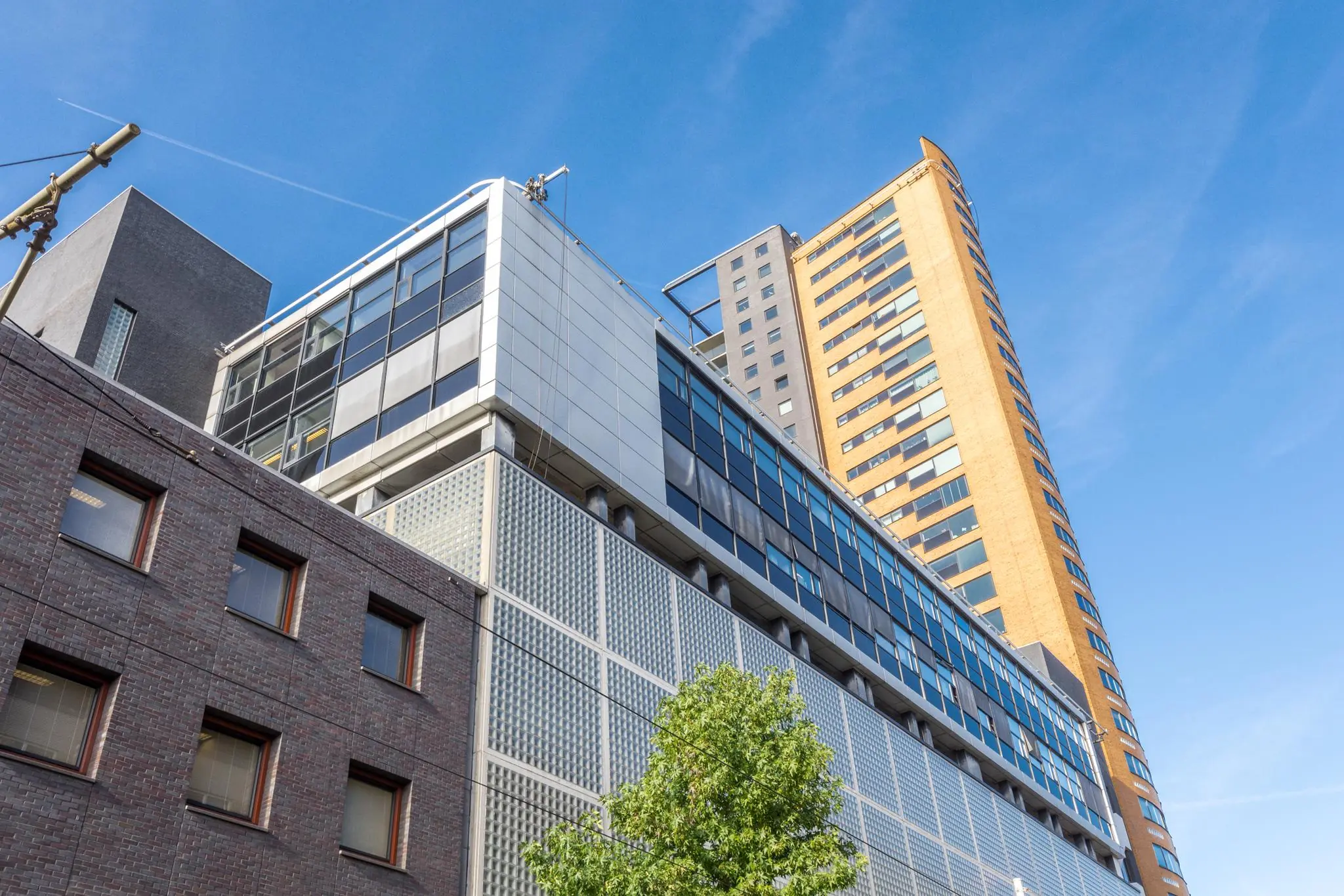 Hoogbouw aan de Westerstraat met moderne gevels en glazen panelen tegen een heldere blauwe lucht.