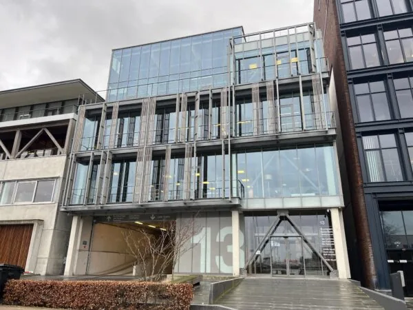 Modern kantoorgebouw aan de Danzigerkade 13 in Amsterdam met een glazen gevel en industriële details.