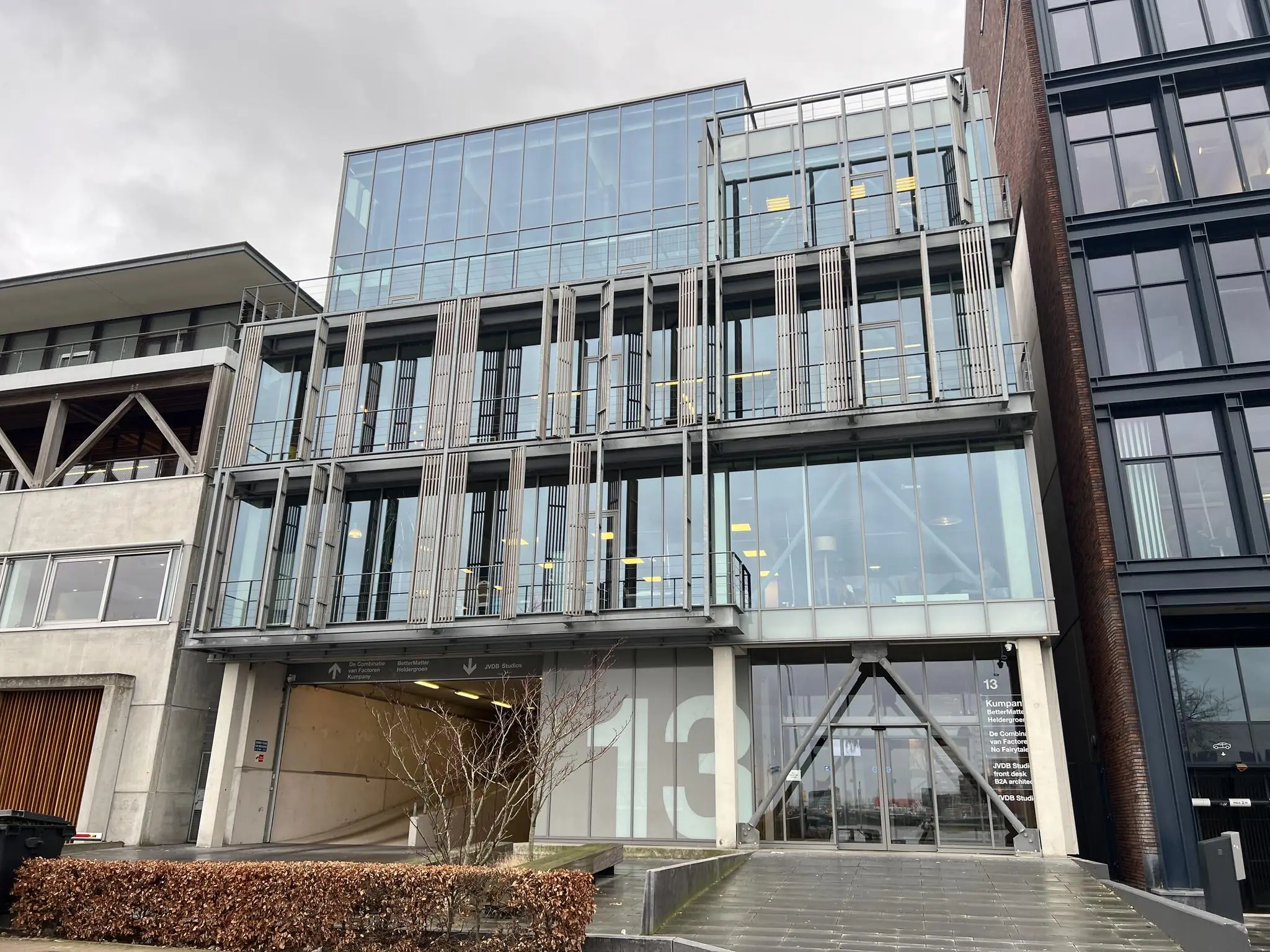 Modern kantoorgebouw aan de Danzigerkade 13 in Amsterdam met een glazen gevel en industriële details.