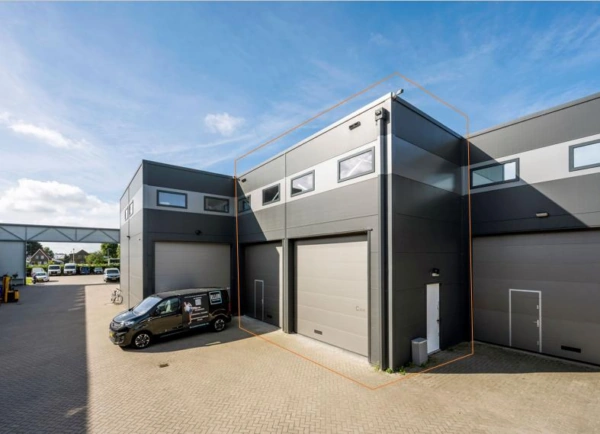 Moderne bedrijfspanden aan de Aalsmeerderweg met grijze gevels en grote overheaddeuren.