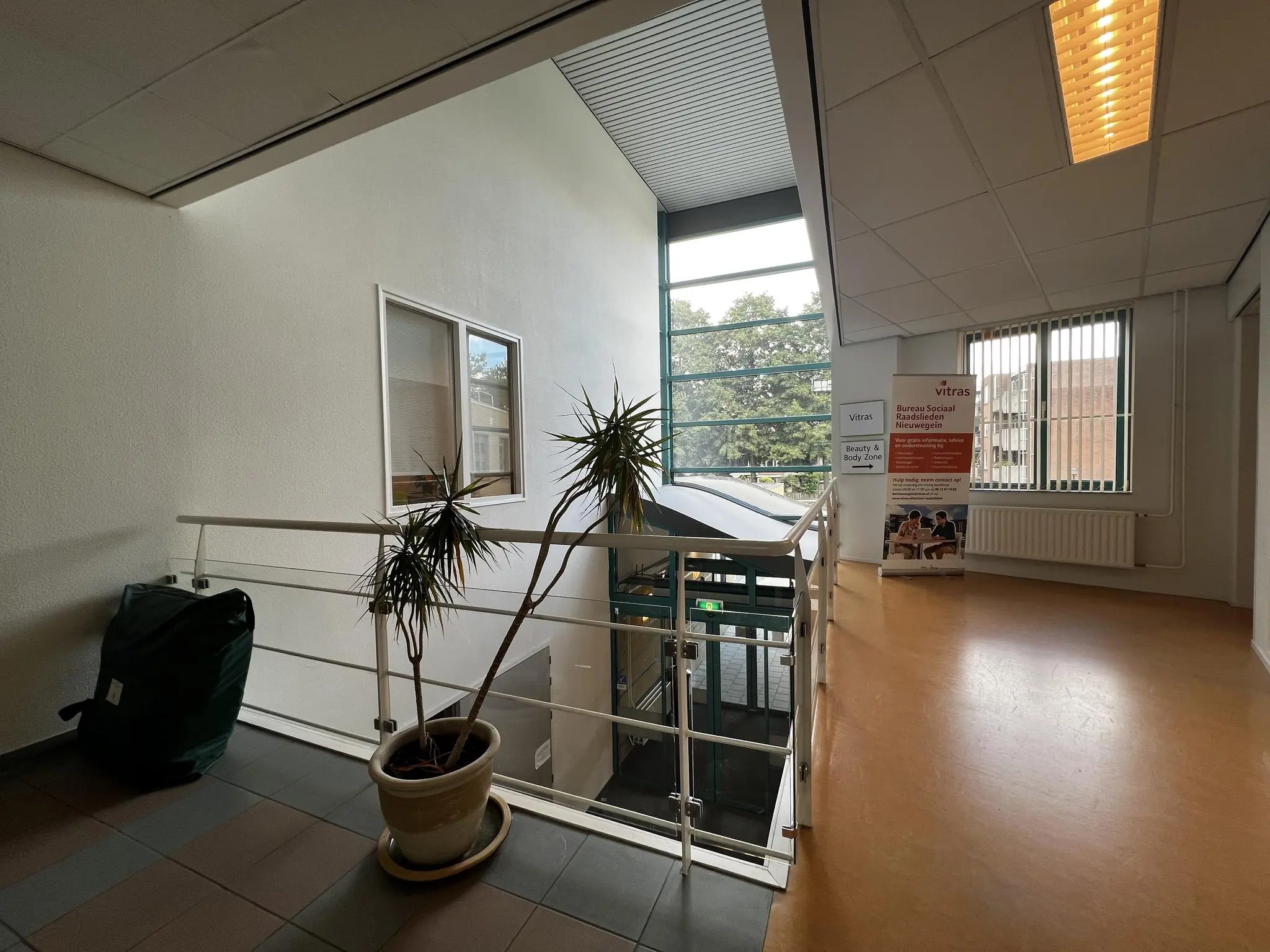 Hal met trap en banners van Vitras en Bureau Sociaal Raadslieden in gezondheidscentrum Zoutkamper Schans.