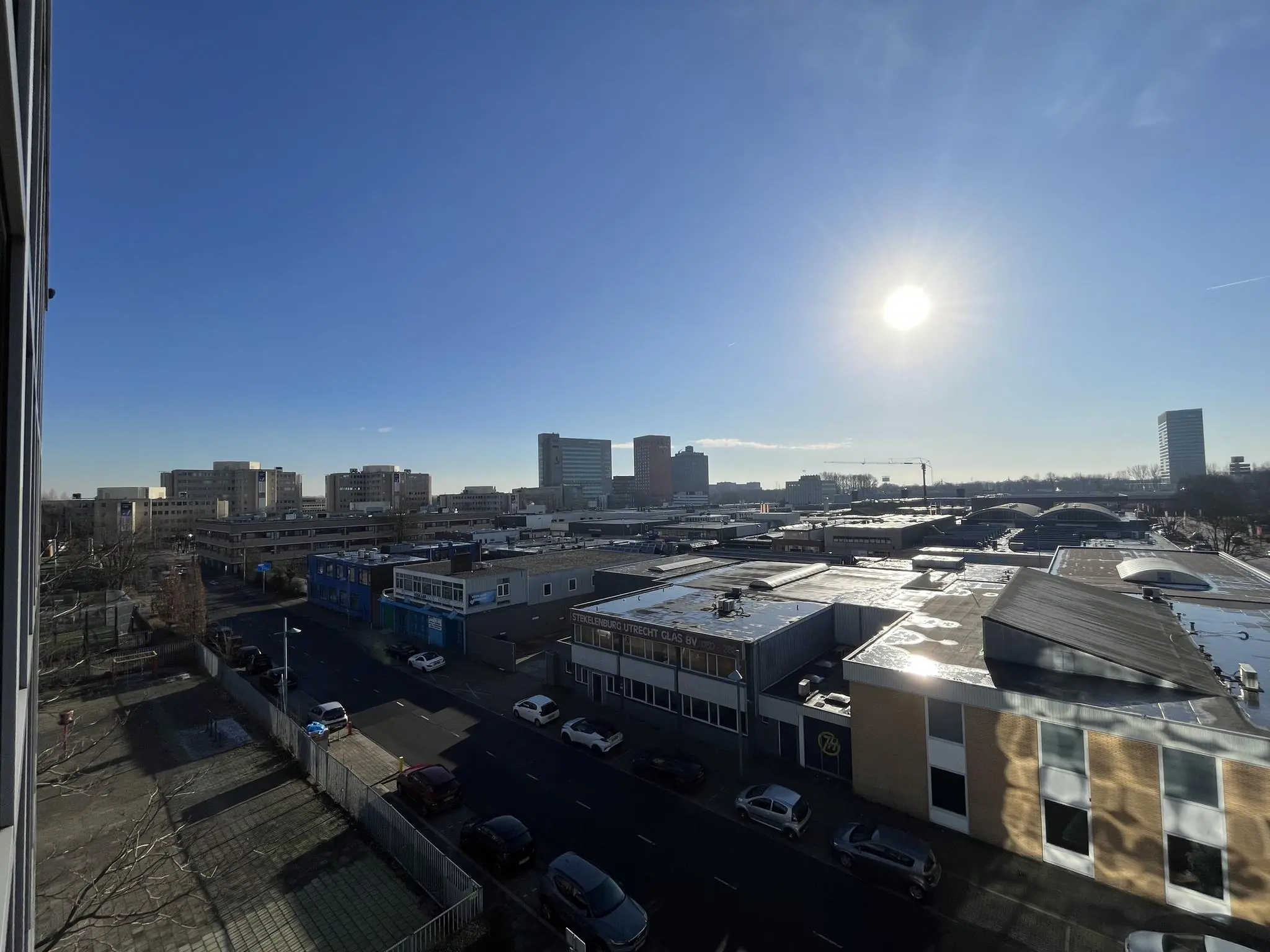 Zonsopkomst boven bedrijventerrein aan de Australiëlaan met kantoren en hoge gebouwen op de achtergrond.