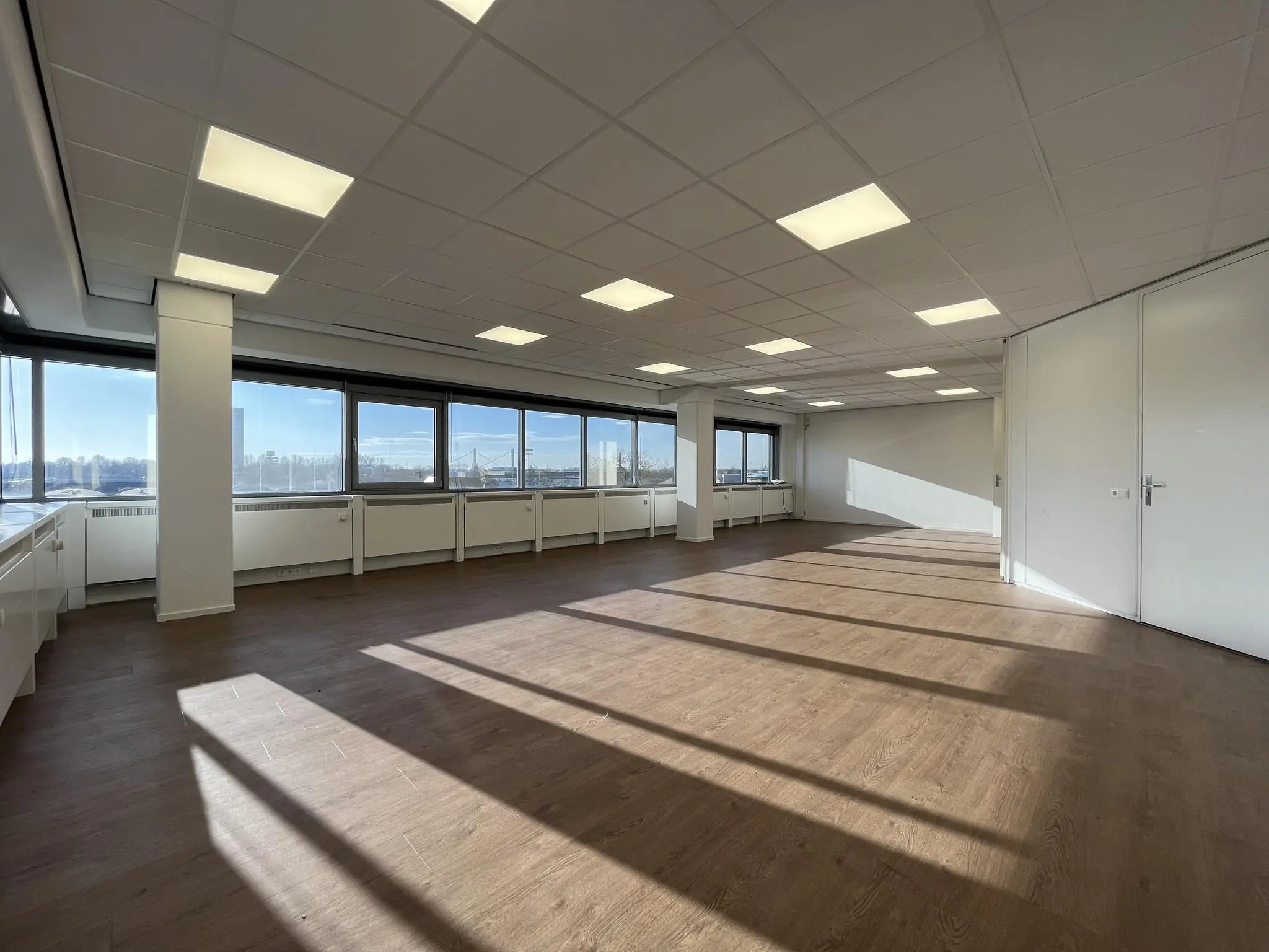 Lichte, lege kantoorruimte aan de Australiëlaan met grote ramen en uitzicht over de stad.