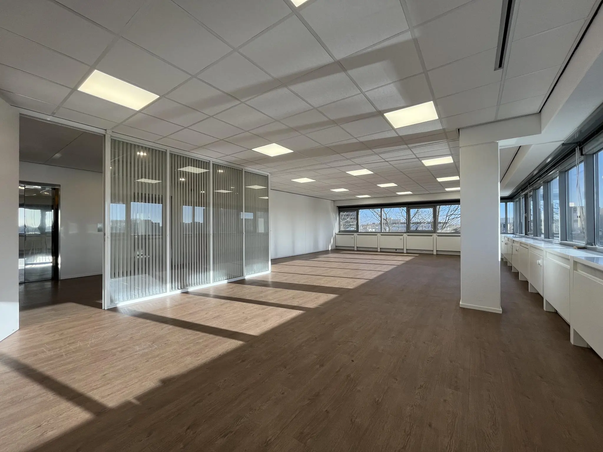 Licht en modern kantoorruimte aan de Australiëlaan met grote ramen en glazen scheidingswanden.