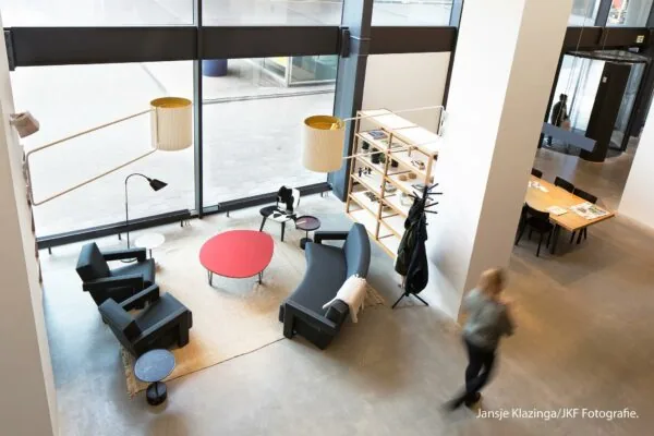 Moderne en lichte lounge- en werkruimte in Hofplein met zithoek, boekenrek en vergadertafel.