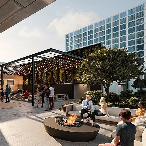 Mensen ontspannen bij een moderne buitenlounge met vuurtafel op een terras aan de Ptolemaeuslaan.