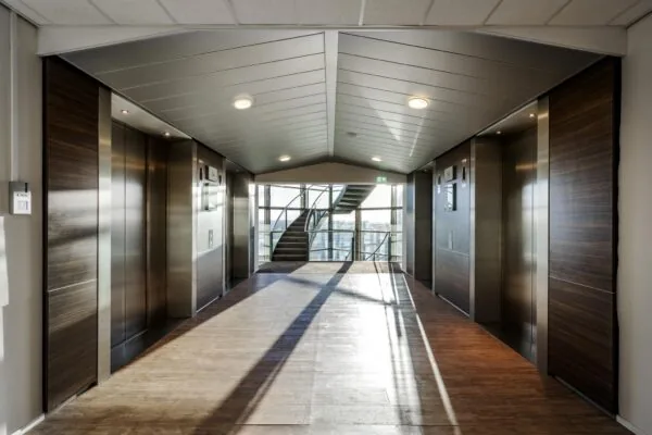 Lichte en moderne liftlobby op de 14e verdieping van het kantoorgebouw aan de Radarweg, met zicht op een glazen trappenhuis.