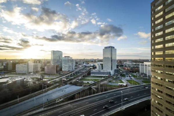 Uitzicht op kantoren en infrastructuur rond de Radarweg in Amsterdam bij zonsondergang.