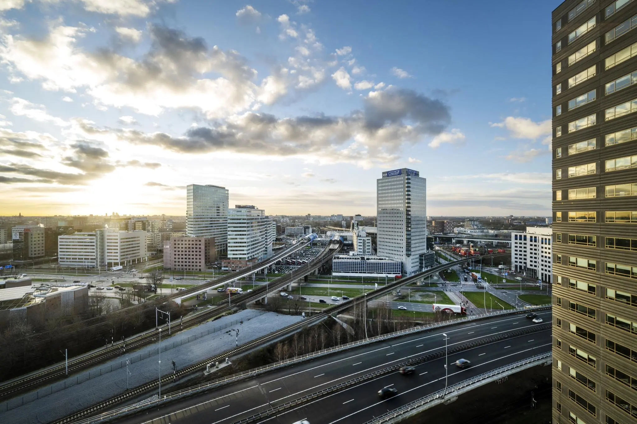 Uitzicht op kantoren en infrastructuur rond de Radarweg in Amsterdam bij zonsondergang.