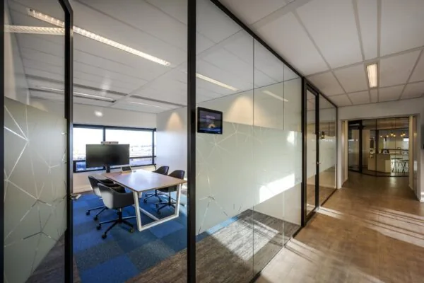 Moderne vergaderruimte in een kantoorpand aan de Radarweg met glazen wanden en uitzicht op de stad.