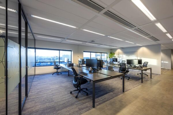 Moderne kantoorruimte aan de Radarweg met werkplekken, bureaustoelen en grote ramen met stadsuitzicht.
