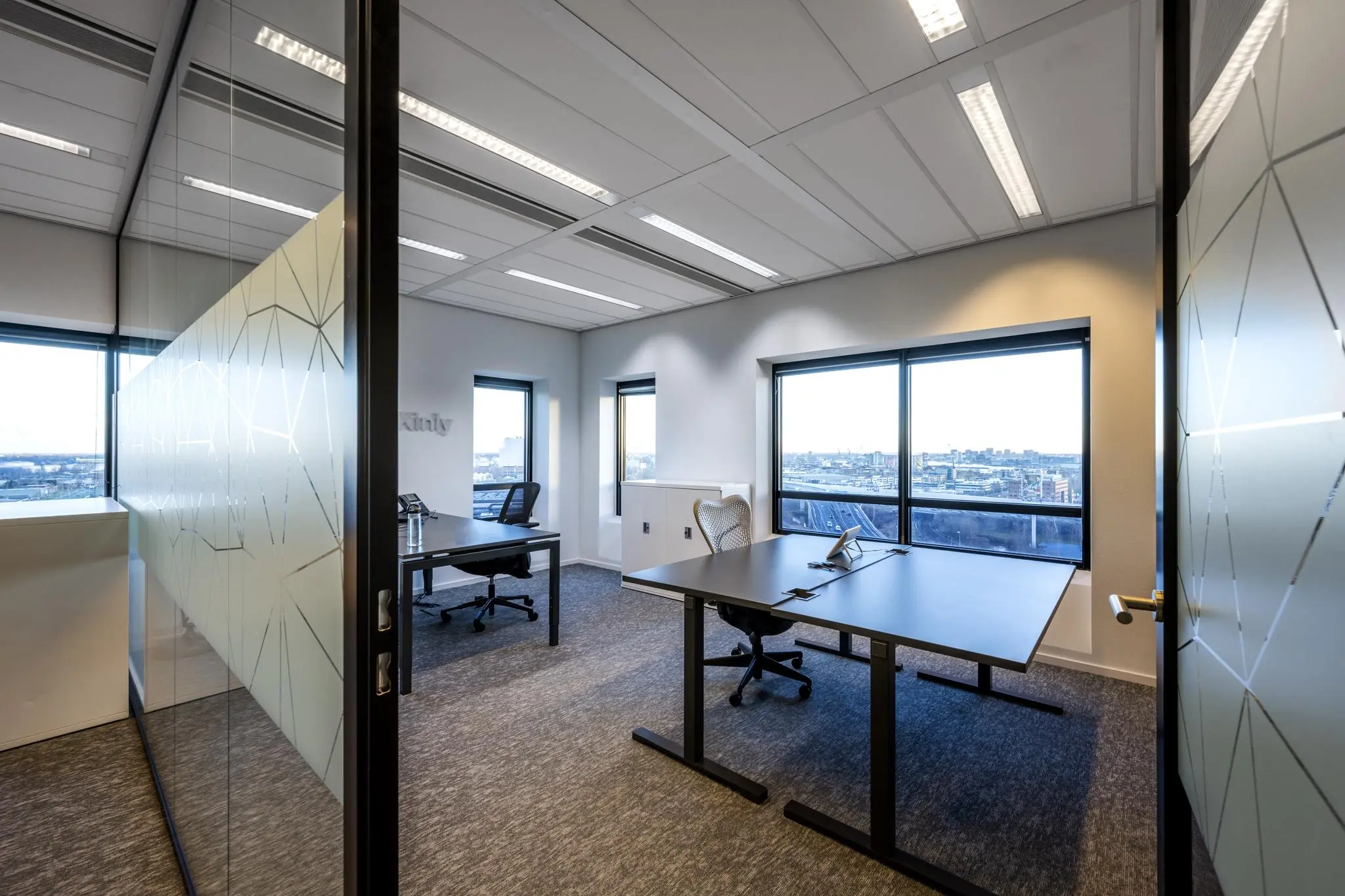Modern ingericht kantoorbureau aan de Radarweg met uitzicht op de stad door grote ramen.
