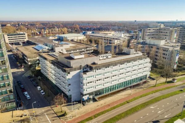 Luchtfoto van een kantoorgebouw aan de Europalaan in een stedelijk gebied met omliggende wegen en bebouwing.