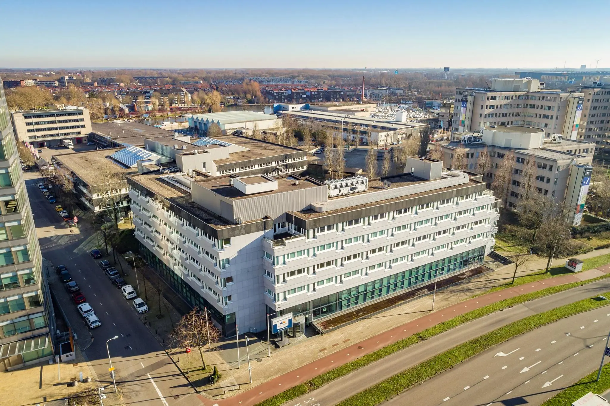 Luchtfoto van een kantoorgebouw aan de Europalaan in een stedelijk gebied met omliggende wegen en bebouwing.