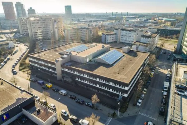 Luchtfoto van een groot kantoorgebouw aan de Eendrachtlaan in een stedelijke omgeving met omliggende hoogbouw.