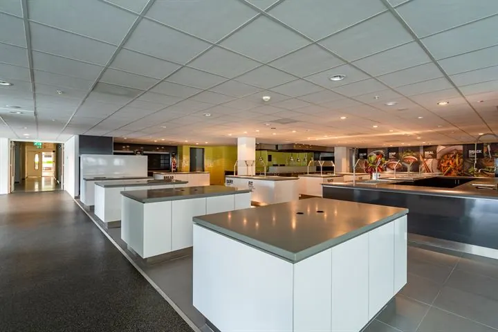 Moderne bedrijfskeuken met meerdere kookeilanden en een strakke, professionele uitstraling aan de Eendrachtlaan.