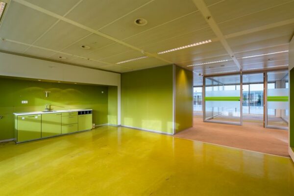 Moderne, lege kantoorruimte aan de Eendrachtlaan met groene wanden, kitchenette en glazen scheidingswanden.