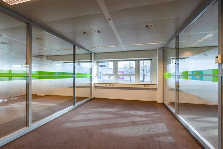 Leeg kantoor met glazen wanden en uitzicht op de Eendrachtlaan in Utrecht.