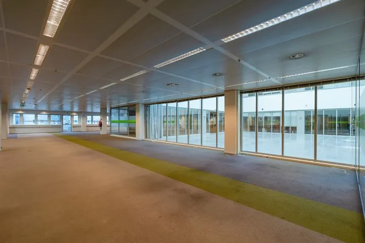 Leeg kantoorpand aan de Eendrachtlaan met grote ramen en een strook groen tapijt.