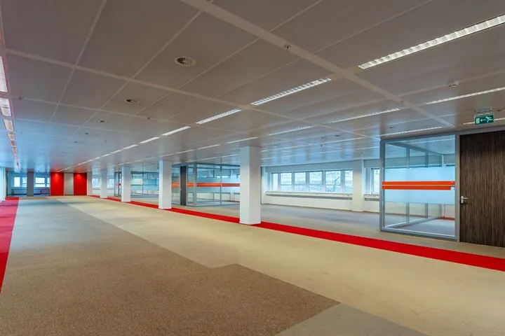 Moderne, lege kantoorruimte aan de Eendrachtlaan met glazen vergaderruimtes en roodtapijtloper.