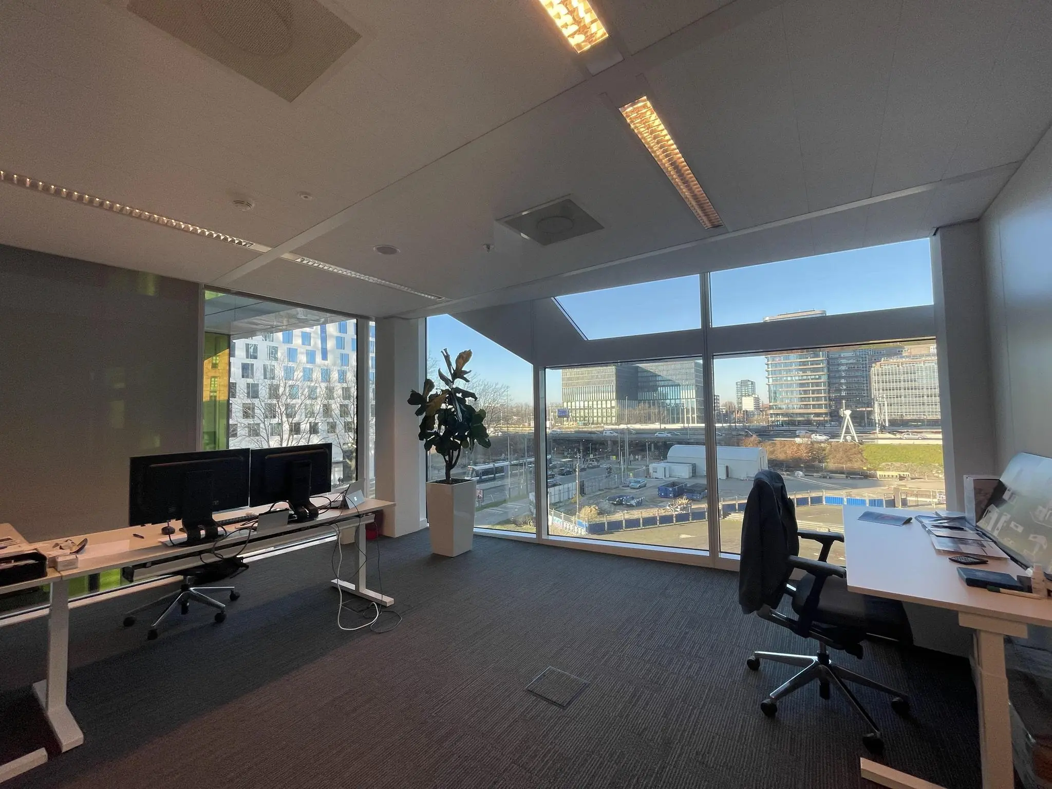 Modern kantoor met werkplekken en uitzicht op de Parnassusweg in Amsterdam.