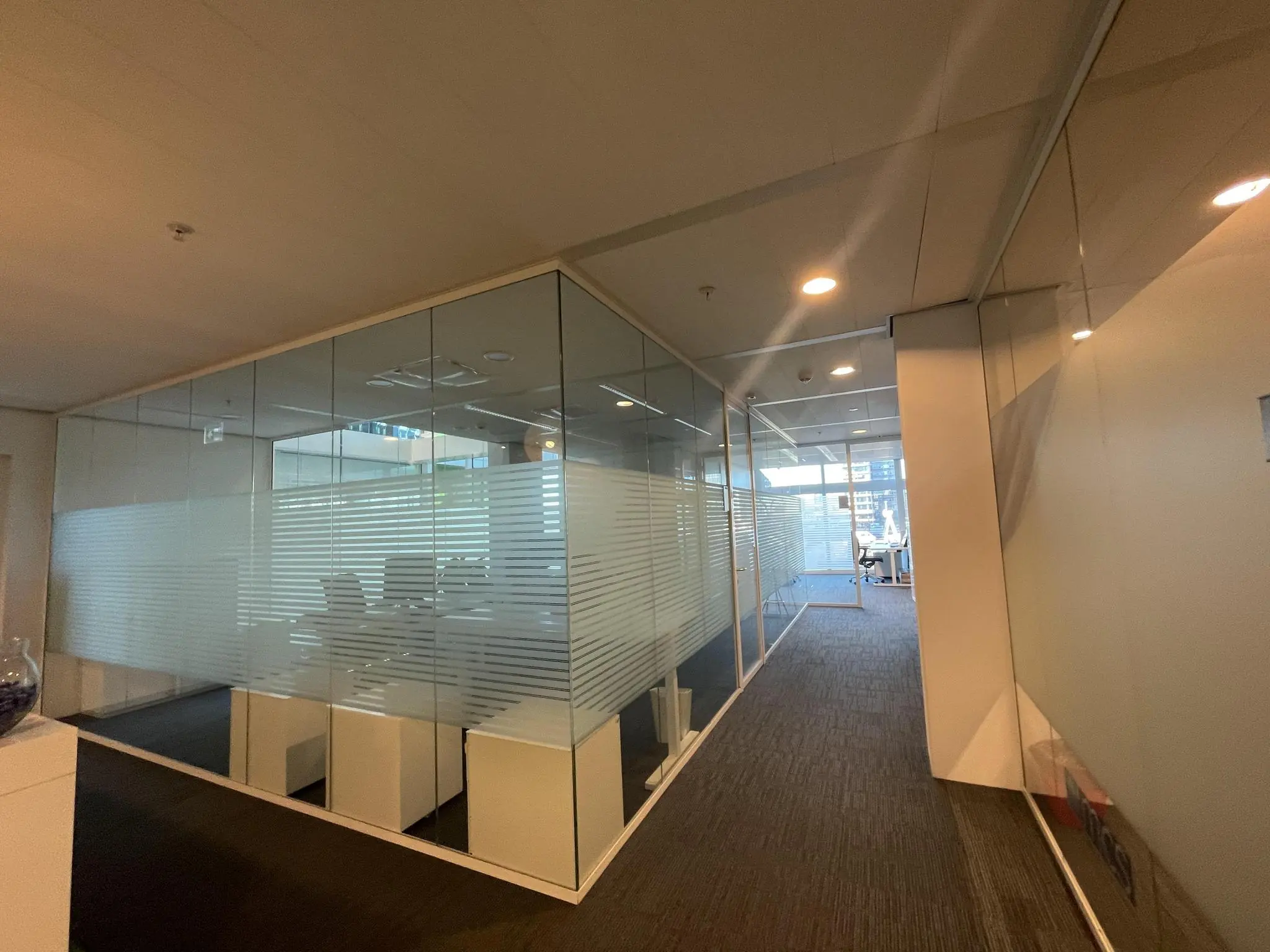 Glazen vergaderruimtes en kantoren aan de Parnassusweg met zicht op moderne werkplekken en verlichting.