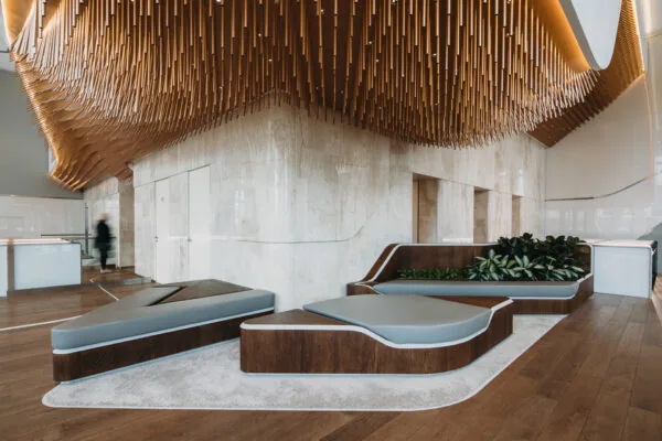 Moderne lobby aan de Parnassusweg met designmeubilair, houten plafondstructuur en geïntegreerde plantenbakken.