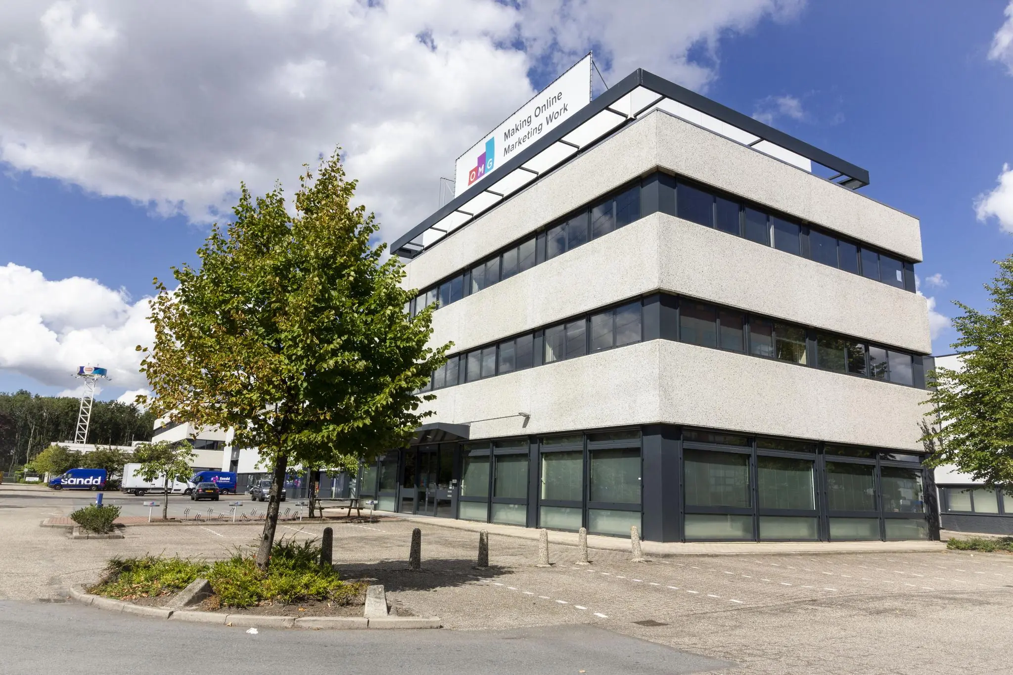 Modern kantoorgebouw aan de Zonnebaan met een bord van "OMG – Making Online Marketing Work" op het dak.