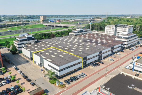 Luchtfoto van een groot bedrijfsverzamelgebouw aan de Zonnebaan met een geel omlijnd bedrijfsunit.