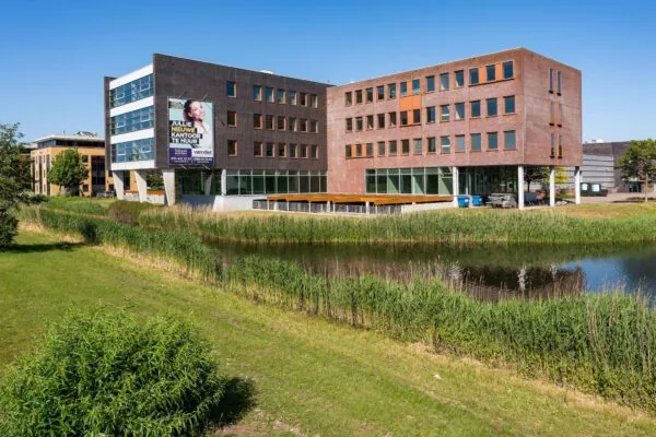 Modern kantoorgebouw Trondheim aan het water met huuradvertentie op de gevel.