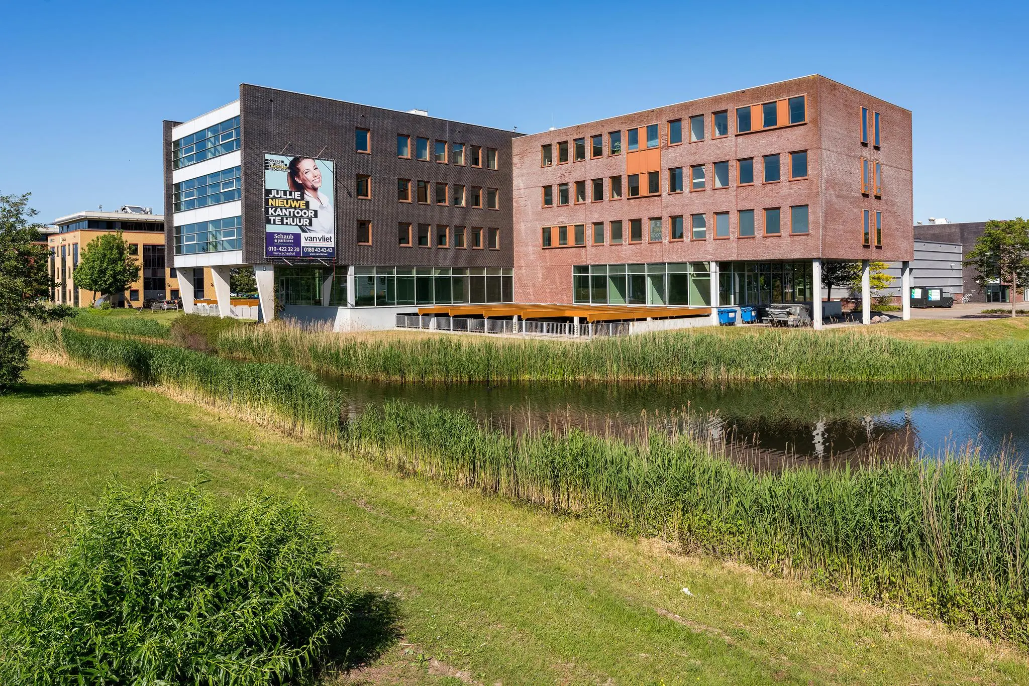 Modern kantoorgebouw Trondheim aan het water met huuradvertentie op de gevel.