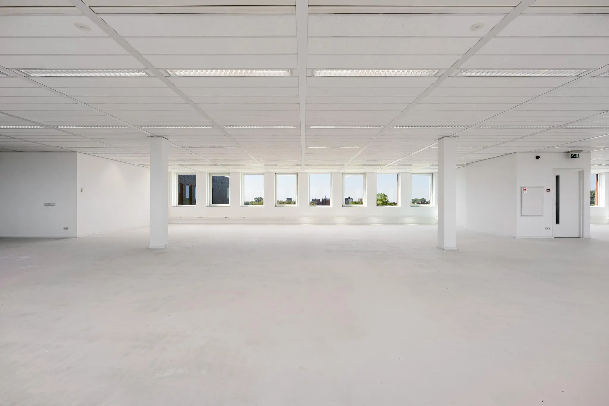 Lichte, lege kantoorruimte in Trondheim met grote ramen en systeemplafond.