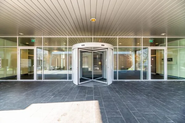 Ingang van een modern gebouw in Trondheim met een glazen pui en een draaideur.