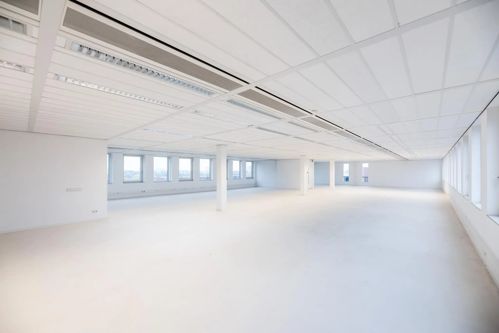 Lichte, lege kantooretage in Trondheim met ramen langs beide zijden en systeemplafond.