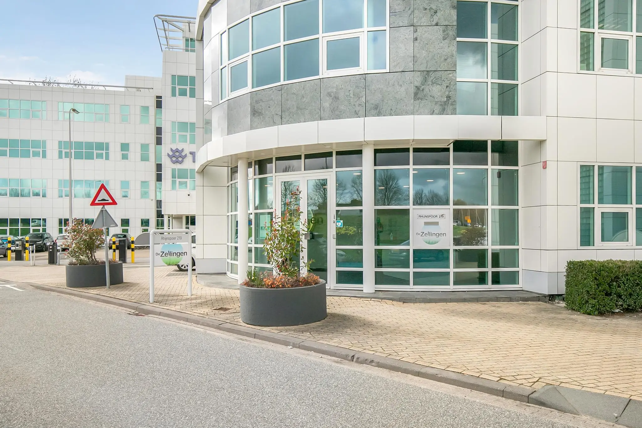 Vooraanzicht van het moderne kantoorgebouw Rhijnspoor 219 met de ingang van De Zellingen.