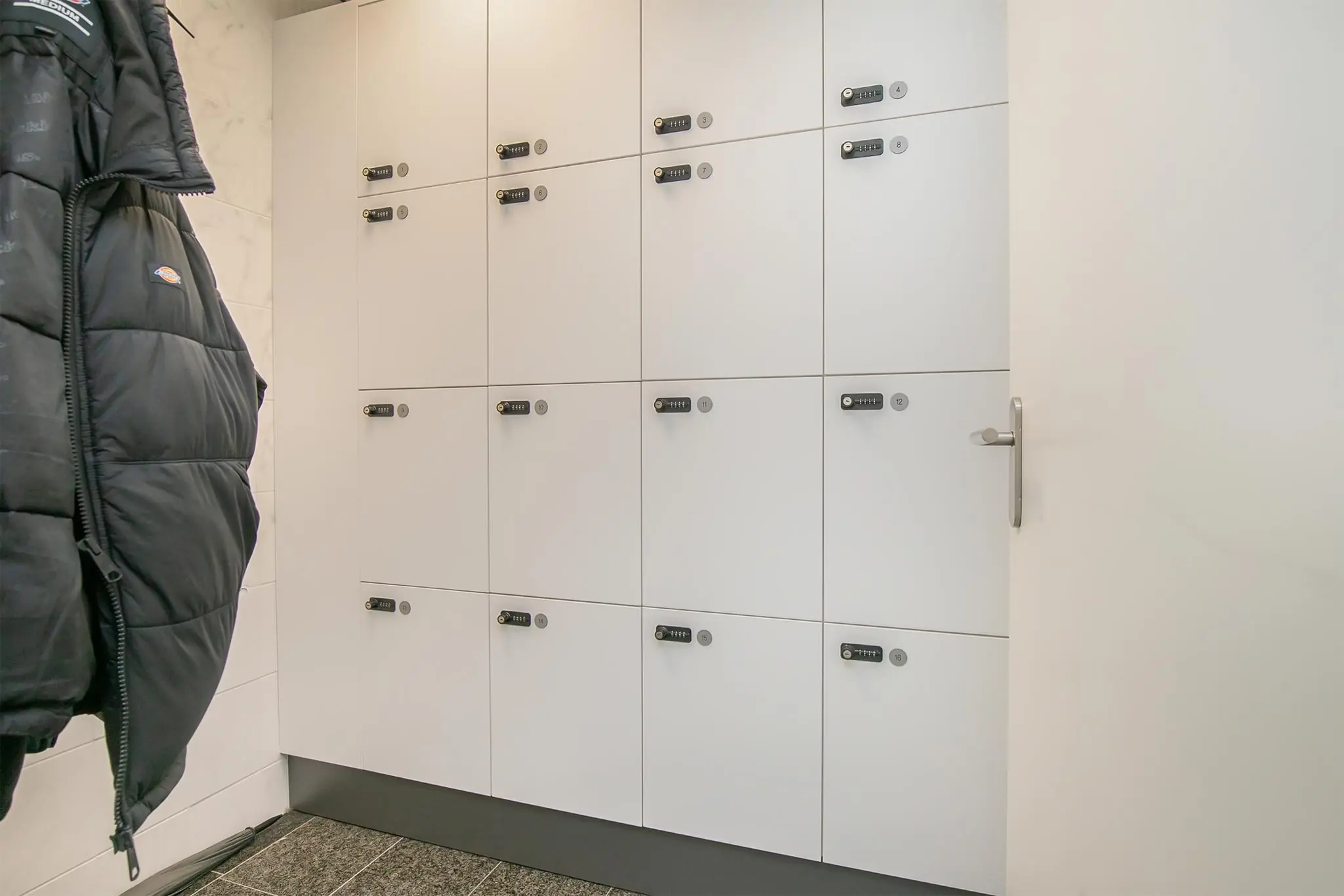 Witte lockerkast met genummerde vakken en cijfersloten in een kleedruimte aan het Rhijnspoor.