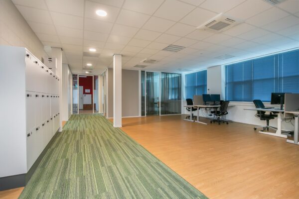 Moderne kantoorruimte met werkplekken, lockers en glazen vergaderruimtes in het Rhijnspoorgebouw.