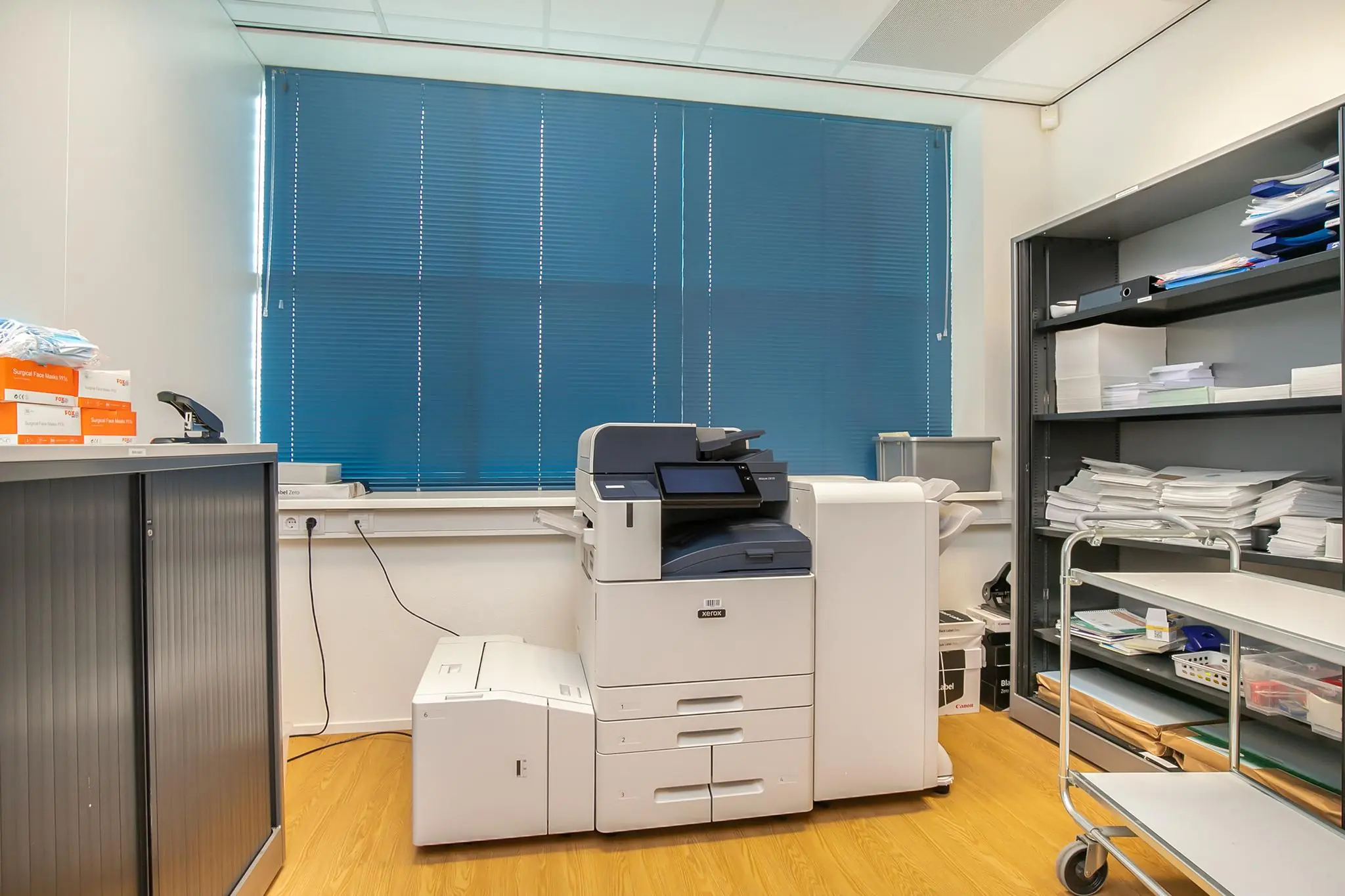Print- en kopieerruimte op kantoor Rhijnspoor met een Xerox multifunctionele printer en opbergkasten vol papier en kantoorbenodigdheden.
