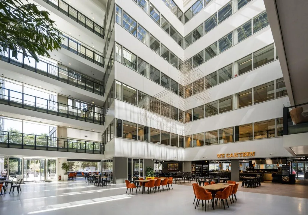 Lichte en moderne kantoorlobby aan de Thomas R. Malthusstraat met zitgedeelte en eetgelegenheid "We Canteen".