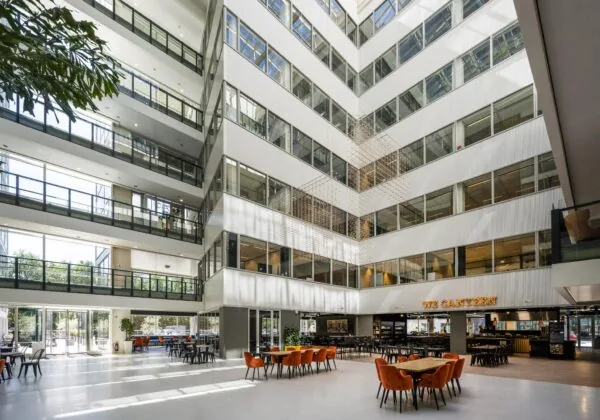 Lichte en moderne kantoorlobby aan de Thomas R. Malthusstraat met zitgedeelte en eetgelegenheid "We Canteen".