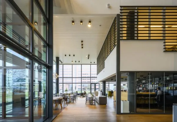 Moderne en ruimtelijke lounge en werkruimte aan de Thomas R. Malthusstraat met hoge ramen en eigentijds interieur.