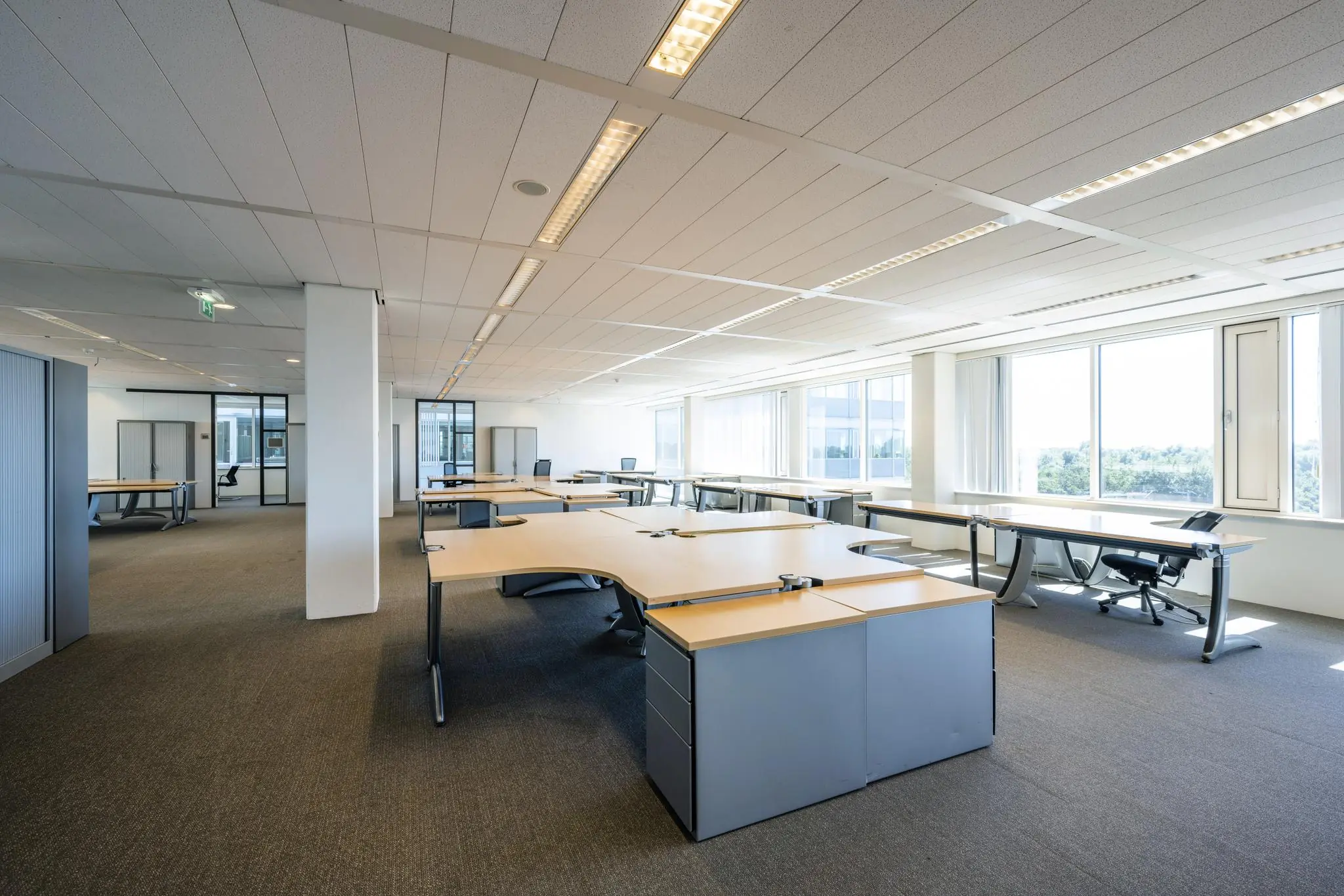 Ruim en licht kantoorinterieur aan de Thomas R. Malthusstraat met moderne bureaus en grote ramen.