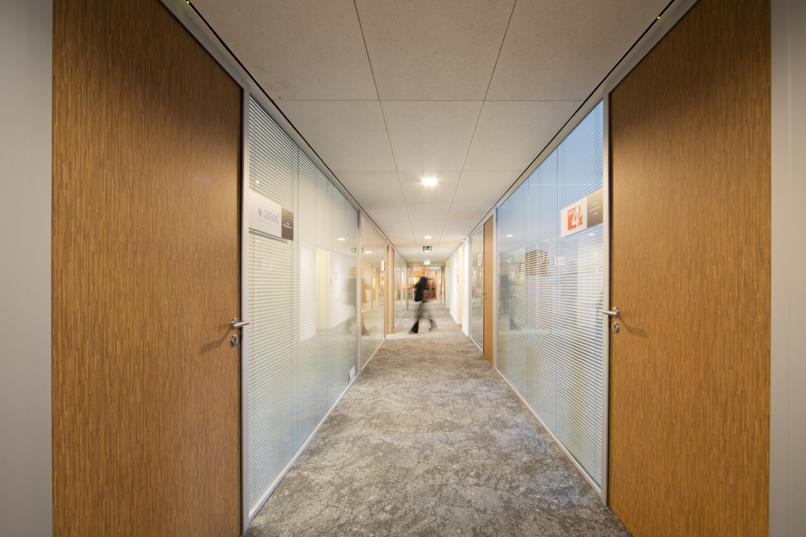 Gang op de 14e etage van 3ELE_UTR_Vleuterweide_51 met houten deuren en glazen panelen.